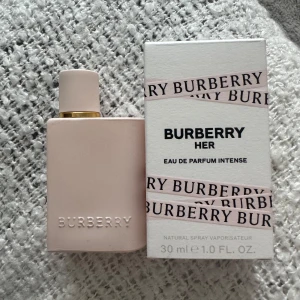 Burberry Her Eau de Parfum Intense - Burberry Her Eau de Parfum Intense i en stilren, ljusrosa flaska med guldiga detaljer. Flaskan rymmer 30 ml och har en minimalistisk design med Burberry-loggan präglad framtill. Kommer med originalkartong i matchande färg. 