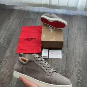 Gråa Loubs - Tjena👋 Säljer nu dessa sjukt snygga Loubs i 10/10 skick för ett skitbra pris! Skorna har en ikonisk röd sula undertill och är perfekt för en avslappnad look👞  Till Loubsen tillkommer boxen och dustbag. Sulan är 28cm📐och skorna är storlek 43! Skorna säljs då dem är för små och är knappt använda!🤩Skriv gärna vid funderingar!📩