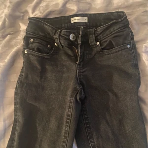 Svarta jeansbyxor  - Snygga svarta jeansbyxor från gina tricot med silvriga knappar och coola bakfickor med lock. Jeansen har klassisk femficksdesign, bälteshällor och dragkedja framtill. Perfekta för dig som gillar en stilren och enkel look.  Bootcut & Storlek 32💗
