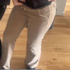 Beiga Juicy Couture byxor med guld detaljer - Snygga Beiga Juicy couture byxor med guld detaljer en knapp saknas där bak men det märks inte så mycket annars är dem riktigt snygga💓