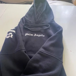 Svart Palm Angels hoodie  - Mycket bra skick förutom att lappen på insidan är lös (sista bilden) annars är den som ny. Snörena har åkt ut i tvätten men går att sätta tillbaks.