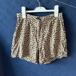 shorts från Lindex - Shorts från Lindex med svartfläckigt mönster. Medium-högmidjade.