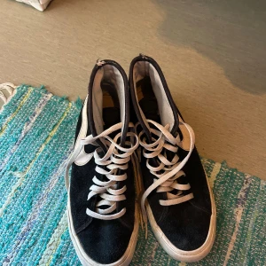Nike Blazer Mid svart/vit storlek 38 - Snygga Nike Blazer Mid i svart mocka med vita detaljer och klassisk vit swoosh. Skorna har högt skaft, vita snören och platt sula. De är väldigt snygga och sköna men inte min stil☺️