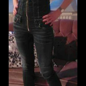 Diesel denim jumpsuit med dragkedja - Säljer en snygg blå denim jumpsuit från Diesel med markerade sömmar och dragkedja framtill. Modellen har fickor både fram och bak samt coola detaljer som bröstfickor med knappar. Materialet är joggjeans och passformen är slim.