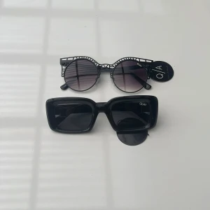 Solglasögon från Quay Australia - Säljer två par glasögon ett par med rektangel aktig båge kallas GOING-SOLO. Annat par med mönster båge och mörk lins kallas FLEUR