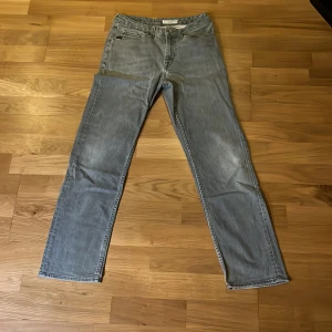 Grå jeans från Tiger of Sweden - Säljer ett par grå jeans från Tiger of Sweden med raka ben och klassisk femficksdesign. Jeansen har en snygg tvättad look och är tillverkade i mjukt denimtyg. Perfekta för dig som gillar stilrena och tidlösa jeans med en modern touch.