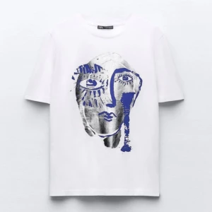 T-shirt med tryck Zara - Vit t-shirt från Zara med ett stort konstnärligt ansiktstryck i silver och blått på framsidan. Klassisk rund halsringning och korta ärmar. 🫐🫐