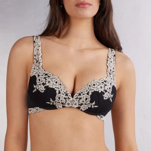 Svart blommig spets-bh från intimissimi - Supersnygg svart bh från intimissimi med lyxig beige spets i blommigt mönster över kuporna och axelbanden. Modellen bär samma storlek. 
