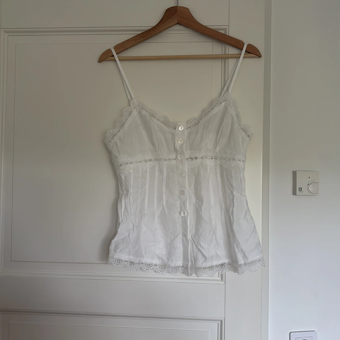 Vit spetsdetaljerad linnetopp