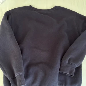 Svart sweatshirt från Zara - En stilren svart sweatshirt från Zara med rund hals och långa ärmar. Tröjan har ribbade muddar vid ärmslut och nederkant, vilket ger en skön och avslappnad passform. Perfekt för chill dagar och enkel att matcha med jeans eller mjukisbyxor.