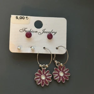 Set med örhängen med blommor och pärlor - Skickar iväg samma dag eller dagen efter🙌🏼Set med fyra par örhängen: ett par silverfärgade hoops med hängande blommor i lila och vitt, ett par små lila studs och ett par små vita pärlstuds. Blommorna har en söt retrostil och hoopsen är i metall. Perfekt för dig som gillar att mixa och matcha.