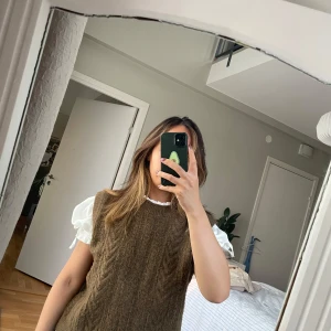 Brun stickad väst från Object - Mysig brun stickad väst från Object med klassiskt kabelstickat mönster. Modellen är ärmlös med rund halsringning och ribbade kanter. Perfekt att styla över en skjorta eller t-shirt för en trendig lager-på-lager-look.