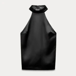 Svart halterneck topp i satin från Zara - Supersnygg svart halterneck topp från Zara i glansig satin. Toppen har hög krage med knäppning i nacken och en stor rosett bak som ger en extra cool touch. Perfekt för dig som vill sticka ut med en elegant men edgy look.