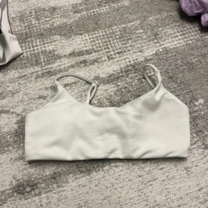 Vit bikiniöverdel i sportig modell - Vit bikiniöverdel i enkel och sportig modell med smala axelband och rak skärning. Tillverkad i ett stretchigt material av 95% polyester och 5% elastan. Perfekt för dig som gillar en clean och stilren look på stranden eller vid poolen.