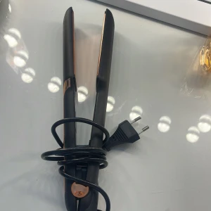 Svart och koppar plattång - Snygg plattång i svart med detaljer i kopparfärg. Har flera värmeinställningar från 160°C till 220°C och en sladd med EU-kontakt. Perfekt för att styla håret med glansiga, raka längder eller mjuka vågor.