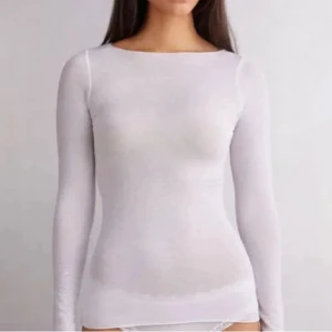 Vit intimissimi - Säljer en enkel och stilren vit långärmad topp i mjuk bomull. Modellen är tight och har rund halsringning. Perfekt att styla med jeans eller kjol för en clean look. Säljer då den inte kommit till användning! 💕