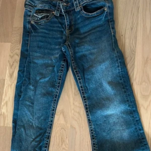 Blå jeans  - Snygga blå jeans med klassisk femficksdesign Jeansen har en normal passform och är tillverkade i slitstarkt denimtyg. Perfekta för dig som gillar en tidlös look med lite vintagekänsla.