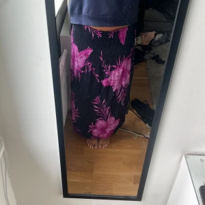 Långkjol - Säljer en svart långkjol med lila blommor på. Den är köpt på en marknad i grekland. Endast använd fåtal gånger.