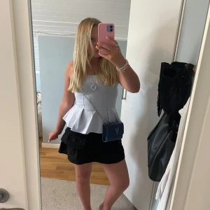Ljusblå bandeau peplum topp H&M - Supersöt ljusblå bandeau topp från H&M med peplumvolang nedtill. Toppen är axelbandslös och har en figurnära passform upptill som släpper ut i en volang. Perfekt att styla med kjol eller jeans för en trendig look.