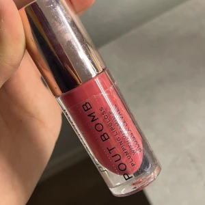 Revolution Pout Bomb Lipgloss Peachy - Plumping lipgloss från Revolution i färgen Peachy. Ger läpparna en snygg glansig finish med en persikotonad nyans. Perfekt för dig som vill ha fylligare och glansiga läppar. Gör läpparna typ brinna för att de ska se fylliga ut💕OBS! Endast testad en gång