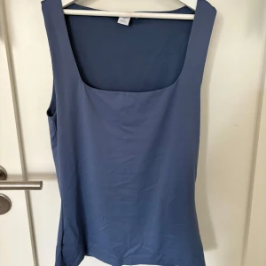 Blå linnetopp med fyrkantig ringning - Ett snyggt linne/topp med breda axelband och fyrkantig ringning