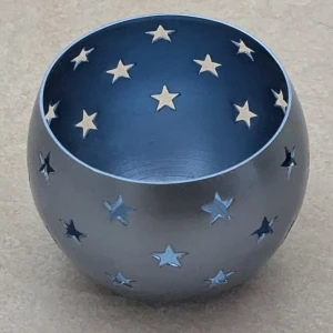 Ljuslykta för värmeljus  - Bilderna visar en rund metallskål med utskurna stjärnor runt om. Skålen har en modern och stilren design, perfekt som ljuslykta eller dekoration.