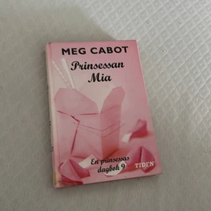 Prinsessan Mia - Prinsessan Mia är den nionde delen i En prinsessas dagbok-serien. Boken har ett rosa omslag med origami och pärlor, och riktar sig till dig som gillar kungliga mysterier, vänskap och drama. Perfekt för unga vuxna som vill ha en lättläst och underhållande berättelse.
