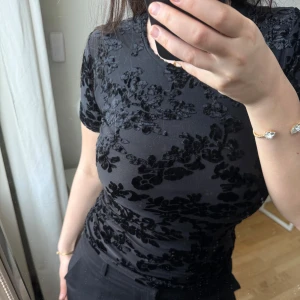 Svart blommig topp - Snygg svart topp med blommigt mönster i sammet🩷