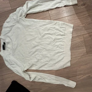 Vit stickad tröja från 157 - Säljer en stilren vit stickad tröja från 157. Tröjan har långa ärmar och en klassisk design som passar perfekt för kyligare dagar. Perfekt för lager-på-lager eller som den är. Pris kan pratas om