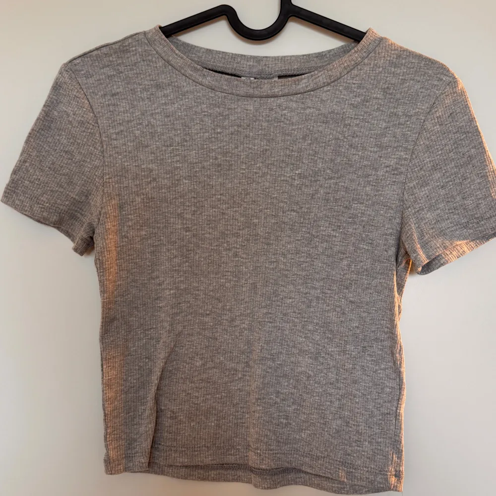 Snygg grå ribbad kortärmad crop top. Mjuk och bekväm. Lätt att matcha/styla. Mycket bra skick, knappt använd!. Yläosat.