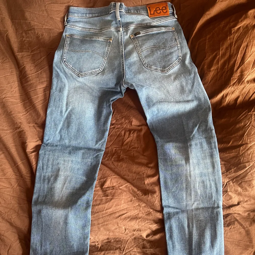 Snygga blå jeans från Lee med klassisk femficksdesign och knappgylf. De har en normal/slim passform och är perfekta för sommaren. Bra skick och riktigt snygg tvätt. W31 L32. Kööööööp!. Farkut & Housut.