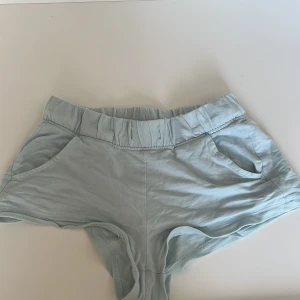 Ljusblå shorts - Säljer ett par ljusblå shorts med elastisk midja och praktiska fickor. Perfekta för varma sommardagar och avslappnade stunder. De är bekväma och lätta att bära.