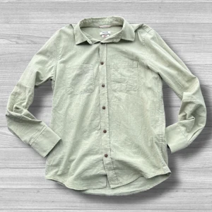 MudoFTS64 skjorta - Snygg grön skjorta från Mudo i storlek S. Skjortan har en klassisk krage och knappar framtill. Två bröstfickor ger en stilren look. Perfekt för en avslappnad stil.