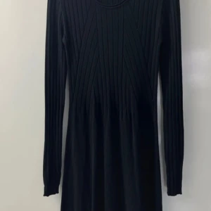 Svart ribbad klänning från Hailys Small - Snygg svart ribbad klänning från Hailys med långärmad design. Perfekt för en stilren look. Klänningen har en smickrande passform och är tillverkad i ett bekvämt material. Storlek Small 