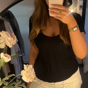 Svart t-shirt med v-ringning - Säljer en jättesnygg svart t-shirt med lite v-ringning. Perfekt basplagg för alla tillfällen. Passar M och S storleksmässigt💌