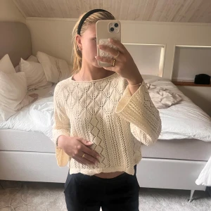 Beige stickad tröja - Säljer en beige stickad tröja med ett fint hålmönster. Tröjan är lite croppad och har trekvartsärmar. Storlek S
