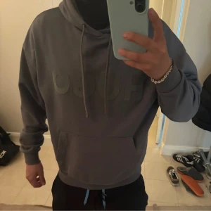 Hugo boss hoodie - Säljer en stilren grå hoodie från Hugo med stor logga på bröstet. Tröjan har en klassisk känguruficka och justerbar dragsko i huvan. Perfekt för en avslappnad look.
