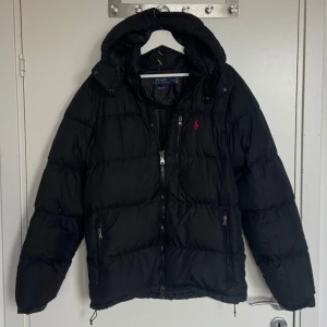 Ralph Lauren Jacka - Ralph Lauren Svart The Gorham Down Jacka.  Storlek M. I jätte bra skick utan defekt. Köpte två år sedan men kom inte till användning mycket. Nypris 5495 kr. Skickar alltid samma eller nästa dag. Skriv ifall om du undrar om något mer.