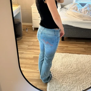 Ljusblå bootcut jeans från Nelly - Snygga ljusblå bootcut jeans med rosa detaljer från Nelly💕använda en gång men inget som syns!