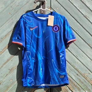 Helt ny Chelsea Fotbollströja 💫 - Hej! Vi säljer just nu denna underbara Chelsea tröjan till ett väldigt bra pris 😍Den är perfekt nu inför sommaren ☀️🌟Tröjan är i storlek S 👕Kontakta oss för mer information ℹ️ 