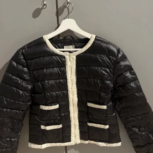 Svart pufferjacka med vita detaljer - Superfin dunjacka. Storlek L men passar en M/S💕