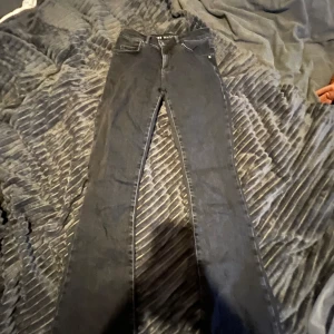Svarta lågmidjade jeans  - Svarta flared jeans low waist syns att dom är använda vid hälarna men annars inte 