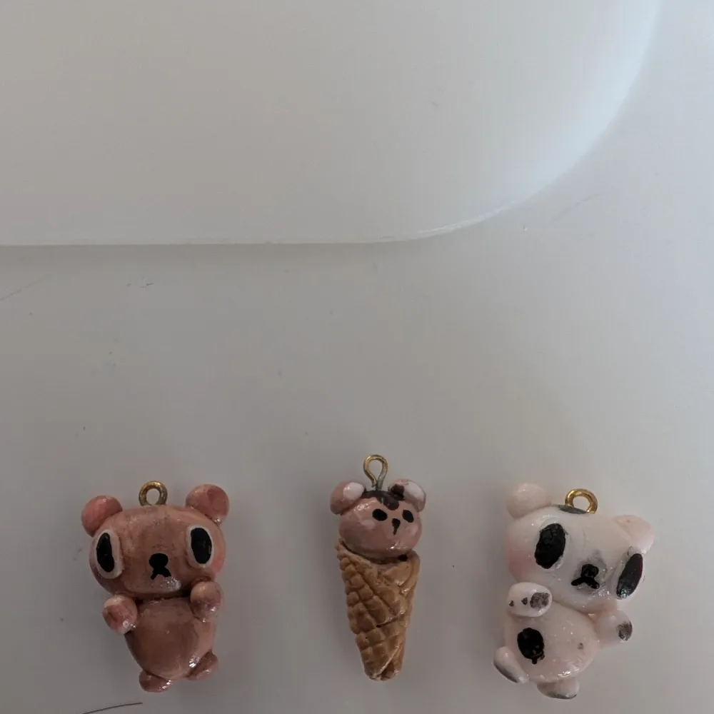 Säljer tre unika handgjorda berlocker i form av björnar. En är brun, en är vit med svarta fläckar och en är en björn i en glasstrut. Perfekta som söta accessoarer till väskor eller nyckelringar. Som den sista bilden visar kan ni se att den bruna björnen inte ser så