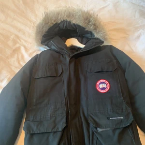 Svart parkajacka från Canada Goose - Säljer en svart parkajacka fråm canada goose, säljer den nu för att den är alldeles för liten och att det börjar bli sommar tider, jackan är inte i bästa skick men den funkar fortfarande bra. Pris och byten kan diskuteras. Den passar mer S eftersom den är liten i storleken