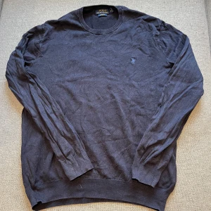  Polo Ralph Lauren tröja - Säljer en stilren mörkblå tröja från Polo Ralph Lauren i slim fit. Tröjan är tillverkad av mjuk Pima bomull och har en broderad logotyp på bröstet. Perfekt för en elegant och avslappnad look.