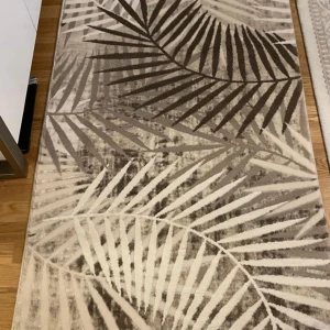 Beige och brun matta från Merinos - Säljer en elegant matta från Merinos i beige och bruna toner med ett stilrent palmbladsmönster. Mattan är rektangulär och mäter 170x250 cm. Oanvänd, i perfekt skick. Passar perfekt i vardagsrum, sovrum eller hall. Pris kan diskuteras 