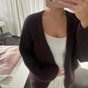 Vinröd stickad kofta - Säljer en mysig vinröd nästan lite lilla aktig stickad kofta med en lös passform från Lindex. Koftan har långa ärmar och en öppen design utan knappar.💗