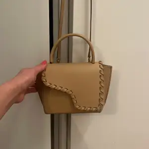 Säljer en stilren beige handväska från ATP Atelier. Den har verkligen inga repor eller defekter använd fåtal gånger  Väskan har en unik flätad detalj på locket och ett praktiskt handtag. Tillverkad i Italien med högkvalitativt skinn. Perfekt för att ge din outfit en elegant touch. Har kvar både kvitto,dust bag och påse💕 