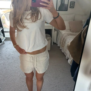 Beiga shorts - Säljer ett par bekväma beiga shorts med resårmidja. Perfekta för en avslappnad stil. De har en lös passform och är gjorda i ett mjukt material.