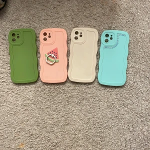 10 kr för alla fyra Fodral till iPhone med vågig design 4 olika  - Säljer flera iPhone-fodral med unik vågig design. Finns i grönt, rosa med vattenmelonring, beige och ljusblå med glittrande detaljer. Perfekt för att ge din telefon en personlig touch!